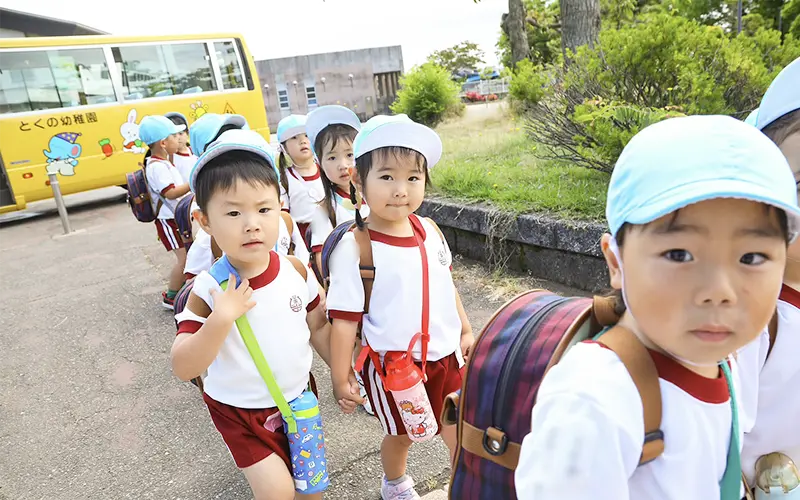 バスから降りて登園する園児たち