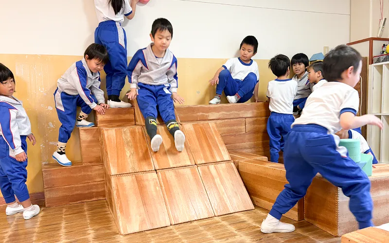 ブロックを組み合わせる遊具で遊ぶ園児たち。滑り台を作っている。