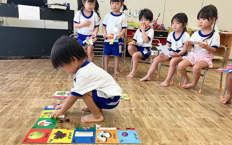 床に置いたカードで単語の勉強をしている様子